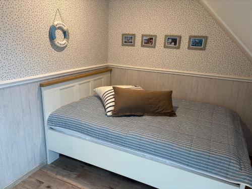 1 cama con almohada en el dormitorio en Balkon Hüs, en Alkersum
