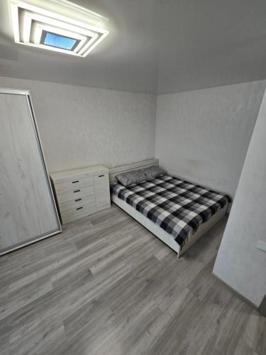 une chambre avec un lit, une commode et un miroir dans l'établissement 1 кімнатна квартира в центрі міста, à Soumy