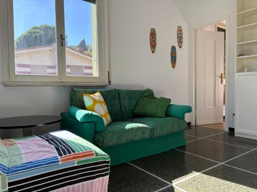 a living room with a green couch and a window at Il terrazzino sul Golfo in Recco