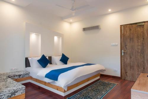 a bedroom with a bed and a wooden door at Solace Suites Hotel & Banquets in Barog