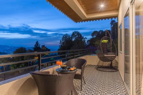 a patio with chairs and a table on a balcony at Solace Suites Hotel & Banquets in Barog
