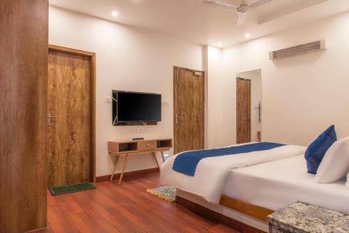 a hotel room with a bed and a television at Solace Suites Hotel & Banquets in Barog