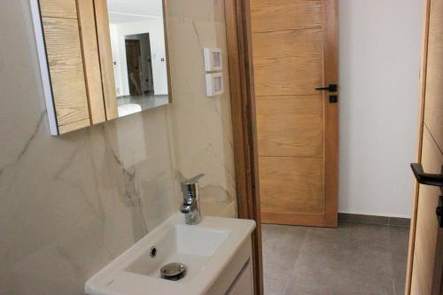 une salle de bains avec un lavabo blanc et un miroir dans l'établissement Villa Les Palmiers, à Temlale