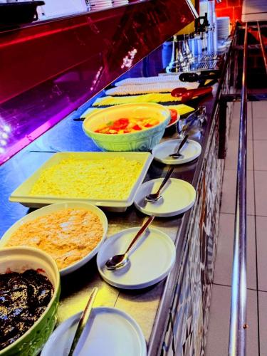 a buffet line with bowls of food and spoons at Rest Up London in London