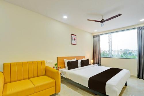 a bedroom with a bed and a yellow couch at Super Townhouse La Vista Inn Grand Hotel in Hyderabad
