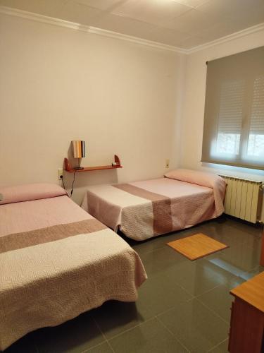 a room with two beds and a window at Casa tío Manolo in Sinarcas