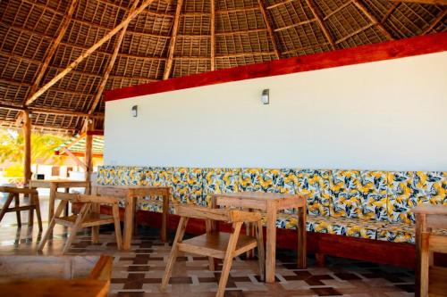 a row of tables and chairs in a restaurant at 1Zi hotel and beach club in Paje