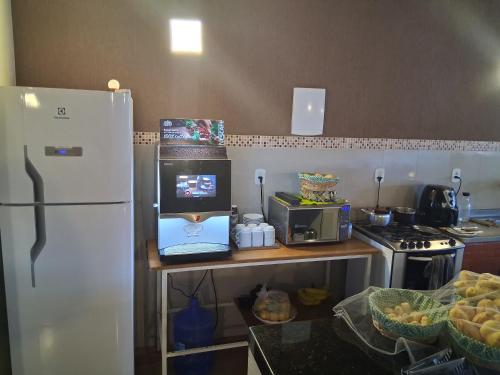 La cuisine est équipée d'un réfrigérateur et d'un comptoir avec un four micro-ondes. dans l'établissement Hospedaria Igarapé, à Miguel Pereira