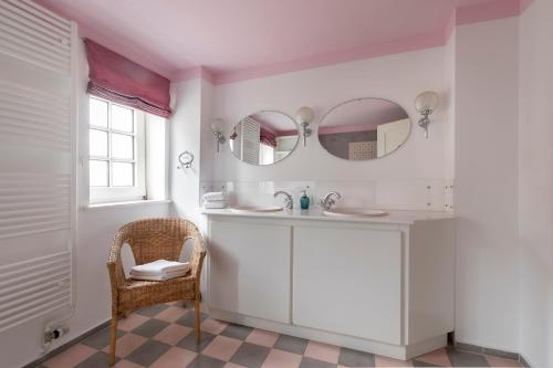 a bathroom with a sink and a mirror and a chair at Die Meierei - mit Pool & Tennisplatz, nahe Ostsee in Harmsdorf