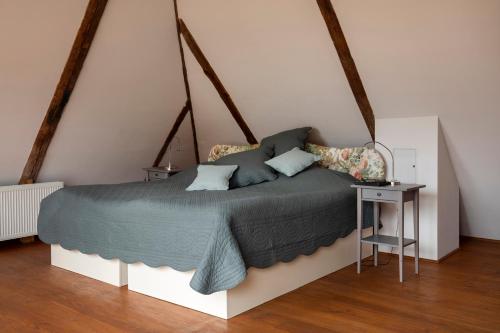 a bedroom with a large bed and a table at Die Meierei - mit Pool & Tennisplatz, nahe Ostsee in Harmsdorf