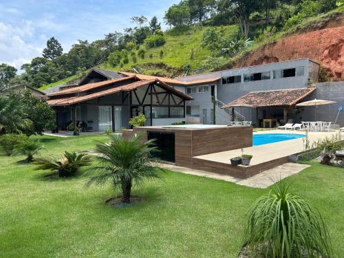 a house with a swimming pool and a yard at Sitio Real Cascata in Teresópolis
