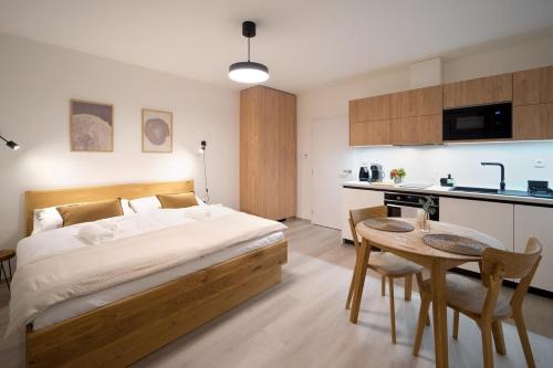 a bedroom with a bed and a table and a kitchen at Apartmány Pro Dva in Dolní Moravice