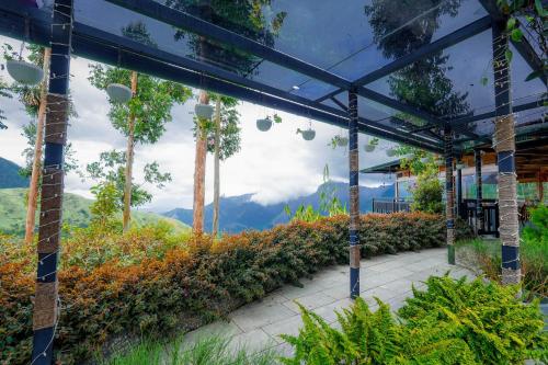 a greenhouse with a view of the mountains at Chandys Drizzle Drops - Munnar Top Station in Munnar