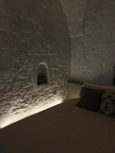 a bedroom with a bed with a light on the wall at Il Fico Deluxe in Ostuni