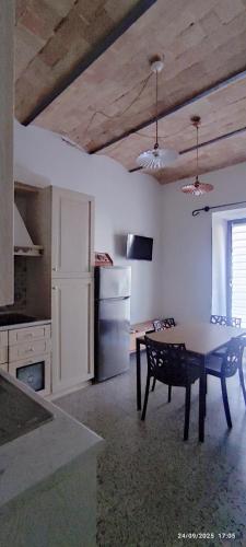 a kitchen with a table and a refrigerator at Civico 95 Alloggio Turistico in Marta