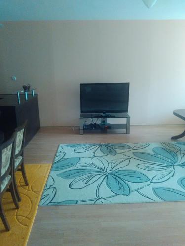 een woonkamer met een flatscreen-tv en een vloerkleed bij Complex Oazis in Ravda