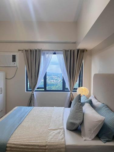 una camera da letto con un letto grande con una finestra di ABE Place a Cebu City