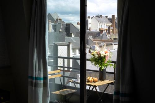 una vista di un balcone con un vaso di fiori su un tavolo di Hôtel Littéraire Gustave Flaubert, BW Signature Collection a Rouen
