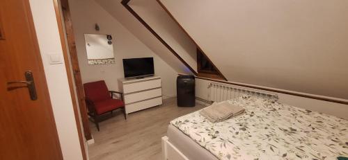 a small room with a bed and a chair at Kasztelania Pod Lipami in Zakroczym