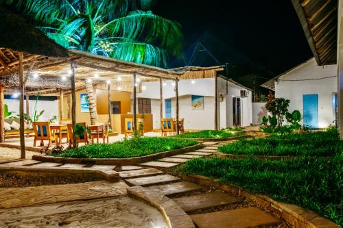 een huis met een tuin 's nachts bij The 5th Element Boutique Hotel in Paje