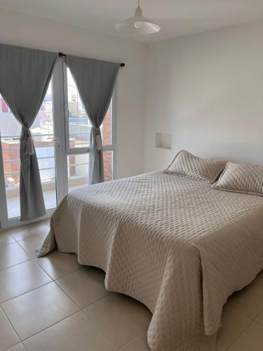 a bedroom with a bed and a large window at Santa Lucía in Playa Unión