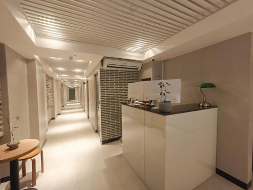 a hallway of a kitchen with a counter and a table at Unit M Hostel in Seoul