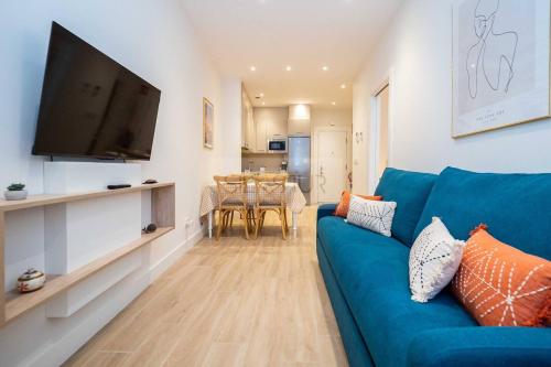 a living room with a blue couch and a flat screen tv at Numavante By Silastur in Gijón