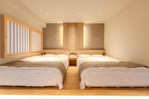 una habitación con tres camas en una habitación en 楽途ホテル 池袋, en Tokio