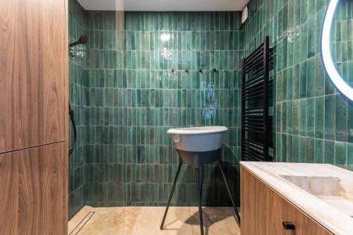 bagno con pareti verdi piastrellate e lavandino di Maison Lacroix - Duplex a Sète
