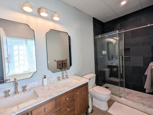 Un baño con dos lavabos, un inodoro y una ducha. en The Optimist Guesthouse | 1, en Camden