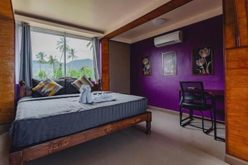 una camera da letto con un letto con pareti viola e una finestra di Lemon House apartment a Mae Nam