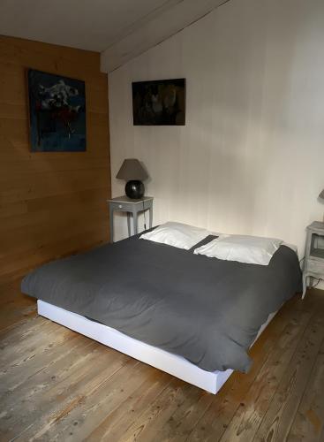 a large bed in a bedroom with a wooden floor at Loft Hangar À Bateaux in Saint-Valery-sur-Somme