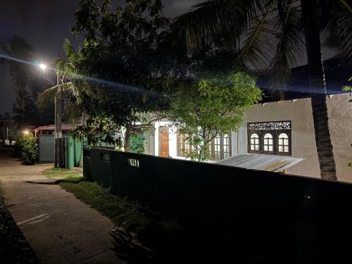 un edificio con una valla al lado de una calle por la noche en Aurora Villa, en Ratgama Hegoda