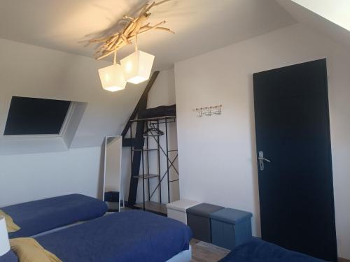 a bedroom with two beds and a ladder and a door at Le Chant des Vagues in Audinghen