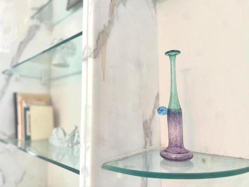 a purple vase sitting on a glass shelf at ROOF and SKY SUITE 5 FLOOR in SORRENTO CENTER in Sorrento