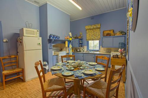 a kitchen with a table and chairs and a refrigerator at Tanunda Cottages in Tanunda