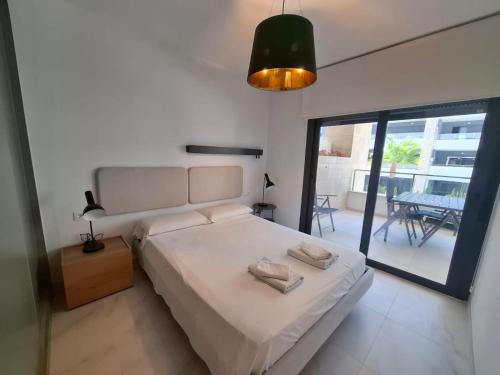 a bedroom with a large bed and a balcony at Flamenca Village by Mar Holidays in Orihuela