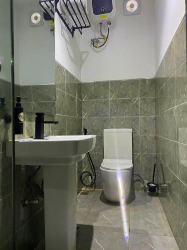 a bathroom with a white toilet and a sink at Ringruby Hotel, Oduduwa Way in Ikeja