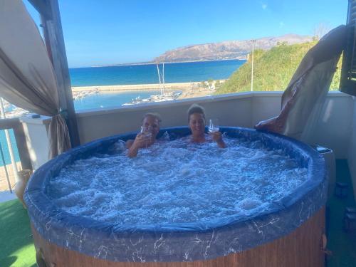 two people in a jacuzzi tub with a view at Baia Marina Suite with private jacuzzi in Balestrate