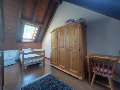 a room with a large wooden cabinet and a table at The elf's house in Tarvisio