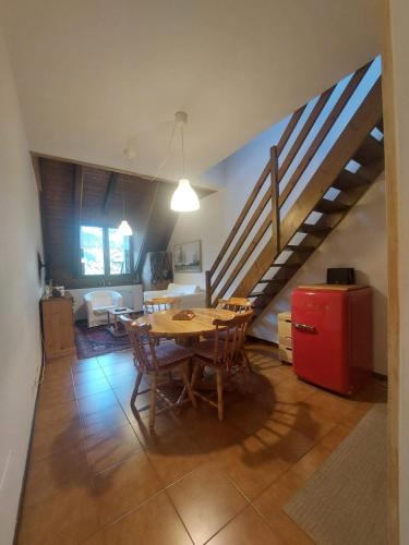 a kitchen and dining room with a table and a staircase at The elf's house in Tarvisio