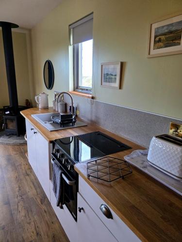 a kitchen with a sink and a stove at Cabin View in Cuminestown