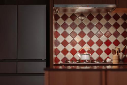 a kitchen with a red and white patterned wall at 回青橙 daidai in Atami