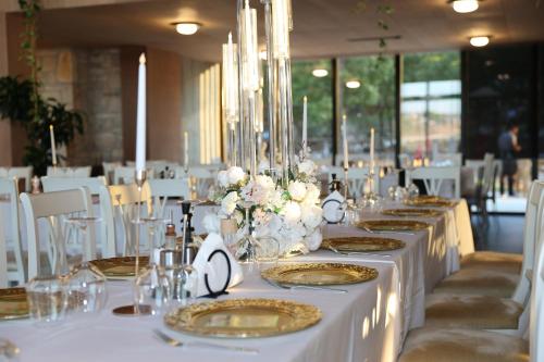 a group of tables with white table cloths and flowers on them at Hani i Qerosit in Kuçovë