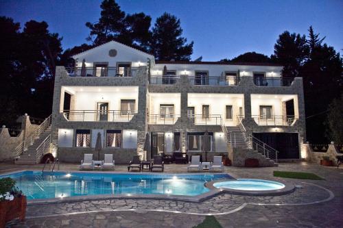 a large house with a swimming pool in front of it at Diwani Luxury Villas in Lixouri