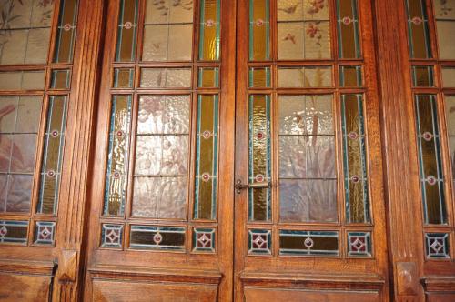 a pair of wooden doors with stained glass at Relais des Vignerons, Chambres d'hôtes in Conilhac-Corbières