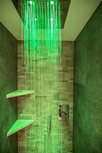 a bathroom with a shower with green tiles at Residence Villa Artic in Campitello di Fassa