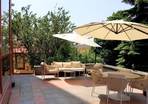 a patio with chairs and tables and umbrellas at Ukraine Hotel in Kyiv