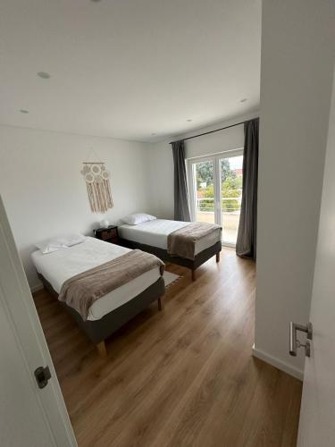 a bedroom with two beds and a window at Solar da Sobreda in Sobreda