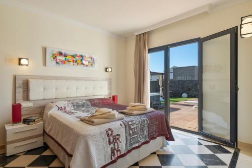 a bedroom with a bed and a large window at Villa Los Alisios 58 in Playa Blanca
